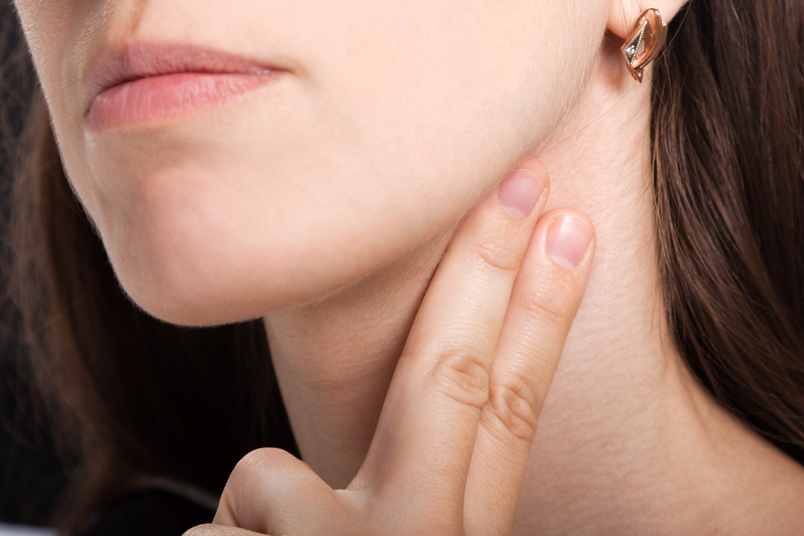 Lady with 2 fingers on her neck.